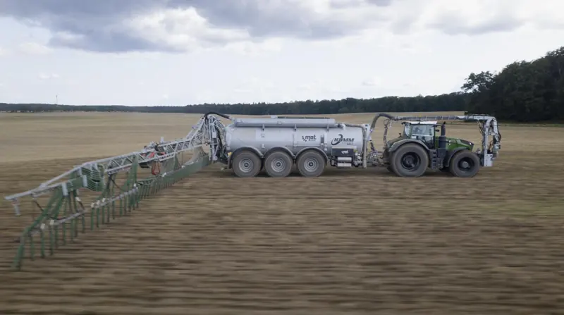 Fendt mit Kumm Güllefass und Schleppschlauchgestänge auf dem Stoppelfeld